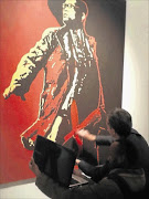 NOT ACCEPTABLE: A man, who was later arrested, defaces a painting of President Jacob Zuma by artist Brett Murray at the Goodman Gallery. Photo: REUTERS