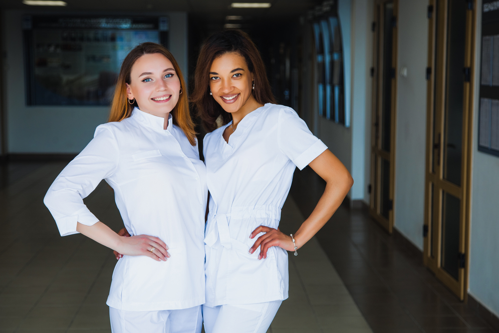 Two nurses smiling and standing with each other