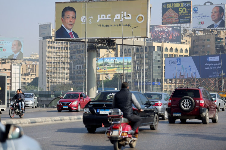 Vehicles drive past posters of presidential candidate and current Egyptian President Abdel Fattah al-Sisi and presidential candidate Hazem Omar, head of the People's Republican Party (PRP), displayed on billboards ahead of the presidential elections to be held inside the country next week, in Cairo, Egypt, December 5, 2023.