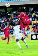 HEADED AWAY: Robert Ng'ambi of Platinum Stars watches as Pirates' Rooi Mahamutsa clears the ball away during last night's exciting clash in Phokeng Photo:  Veli Nhlapo