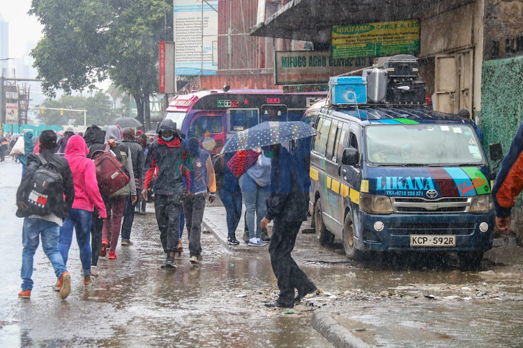 City dwellers and most travelers traveling upcountry for the festive season are caught by the rain as they find their way to Machakos Bus Station Nairobi on Tuesday 21, December./WILFRED NYANGARESI