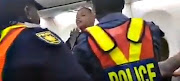 A screengrab of video depicting police trying to remove a passenger during a heated argument on a flight bound for Johannesburg on January 20 2018.