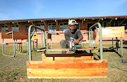 Bonginkosi Zondi cuts a desk to make it a single-seater so as to comply with social distancing rules in classrooms at Zwelibanzi High School in Umlazi, Durban. 