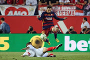 Sevilla's Argentinian midfielder Ever Banega is jumped over by Barcelona's Argentinian forward Lionel Messi during the Spanish 