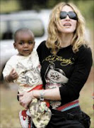 MATERIAL MOM: Madonna arrives in Britain with baby David Banda whom she hopes to adopt. Pic. Karel Prinsloo. 17/04/07. © AP.