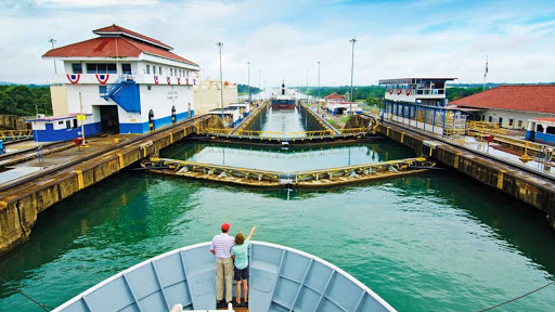 A dad and child take in the historic Mira Flores Locks as a Lindblad Expeditions vessel passes through the Panama Canal. 
