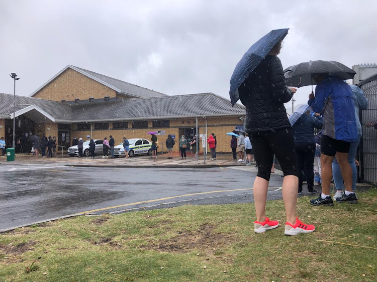 Umbrellas and raincoats helped voters keep their spirits up in the queue outside the Fish Hoek Library polling station.