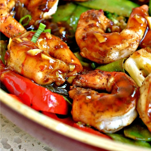 An easy one skillet stir fry recipe with shrimp, red peppers, onions, broccoli, snow peas and a salty sweet garlic ginger Asian sauce.  Serve over rice or zucchini noodles for a complete meal.