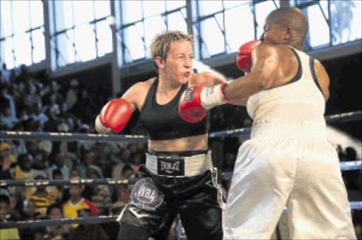 SPEED QUEEN: Noni Tenge eats a barrage of punches from American Layla McCarter during their fight at Orient Theatre on Sunday.pHOTO: MARK ANDREWS