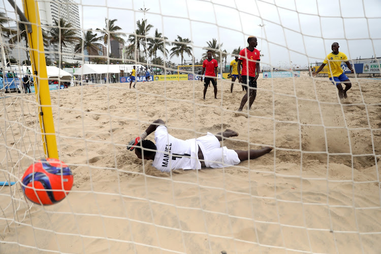 Stephano Walles Mapunda of Tanzania beats Mozambican goalkeeper Manuel Domingos Tivane in their clash during the COSAFA Beach Soccer Tournament in Durban.