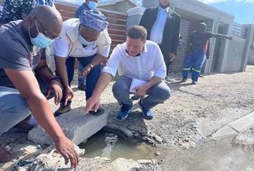 Cape Town mayor Geordin Hill-Lewis inspects a sewage spill with residents.