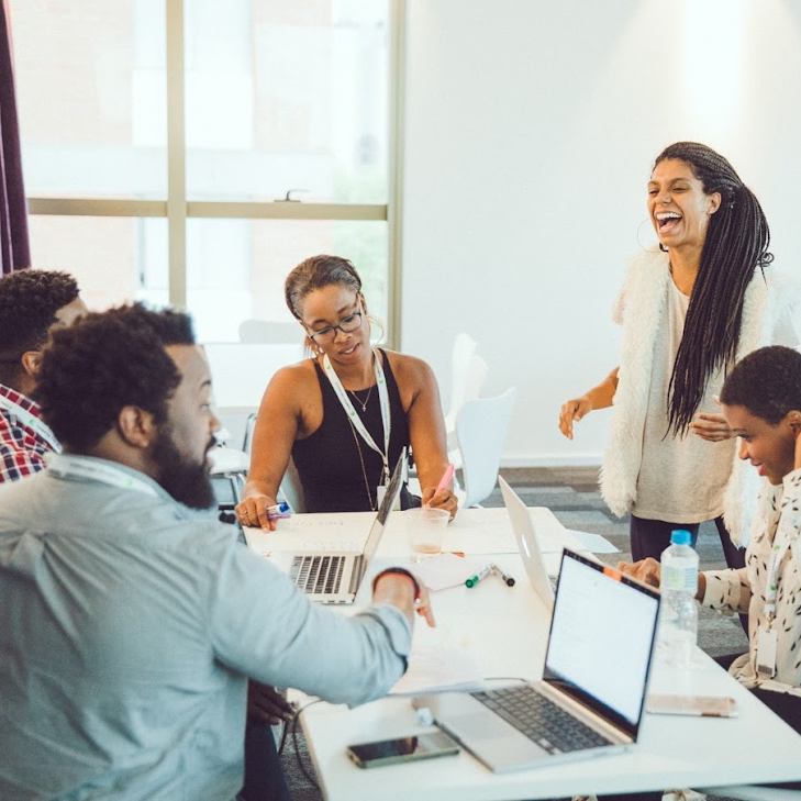 group of campus members working, woman laughing