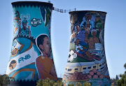 A cow grazes on grassland nearby the colourful Orlando Power Station cooling towers in Soweto. Today marks annual Earth Day which is celebrated on 22 April.