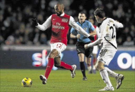 FIRING BLANKS: Arsenal striker Thierry Henry dribbles past Swansea City's Angel Rangel during their Premiership match at the Liberty Stadium in Swansea, South Wales, on Sunday. Photo: REUTERS