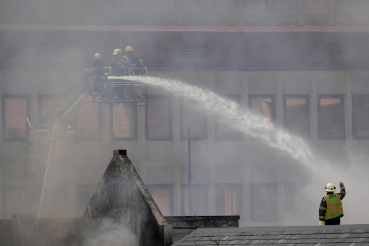 Firemen at work in parliament where a fire broke out in Cape Town on Sunday. REUTERS/Mike Hutchings