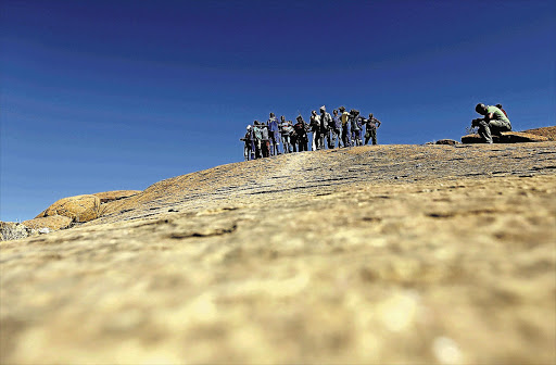 A HARD PLACE: Miners gather at a koppie in Marikana yesterday on the eve of the commemoration of the killing a year ago today of 34 striking miners from Lonmin's platinum mine in North West.