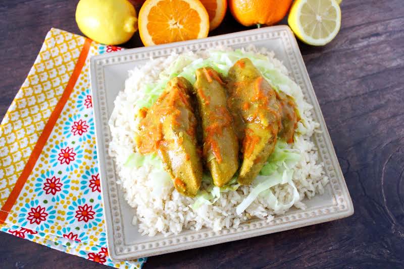 A Platter Of Crock Pot Citrus Chicken Served Over Cabbage And Rice.