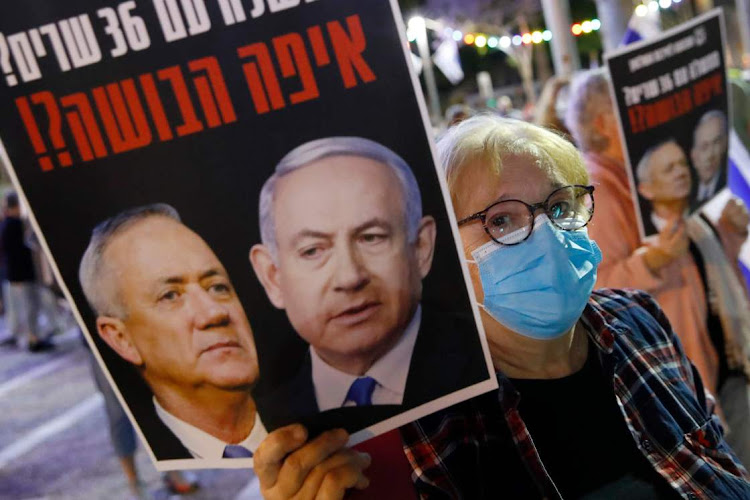 An Israeli woman wearing a protective mask takes part in a demonstration in Tel Aviv's Rabin Square on Saturday in favour of the supreme court blocking the coalition government agreement between Prime Minister Benjamin Netanyahu and his rival-turned-partner Benny Gantz.