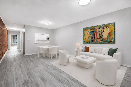 Living room with abstract painting and white furniture in this luxury property for sale in Le Plateau-Mont-Royal ($312,765)