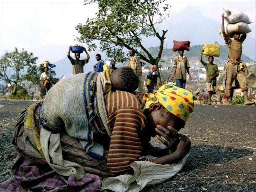 A Rwandan woman collapses with her baby on her back alongside the road connecting Kibumba refugee camp and Goma, July 28, 1994. /REUTERS