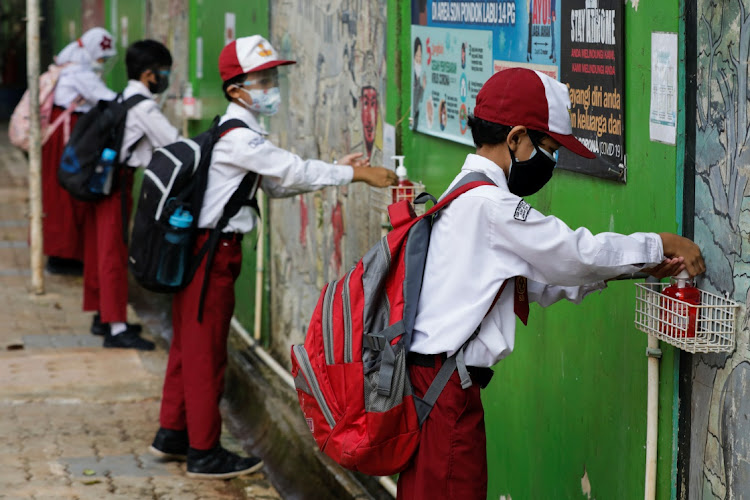 Elementary school students wearing face masks wash their hands after a class as schools reopen on trial basis after the government extended restrictions to curb the spread of coronavirus disease (Covid-19) in Jakarta, Indonesia, August 30, 2021.