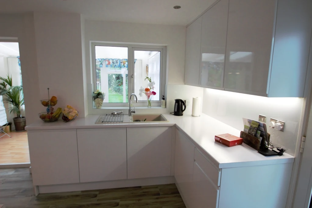 Boxed in wall area reduced, washing machine installed to right of sink and integrated dishwasher to left. Washing machine is now behind a kitchen cupboard door.