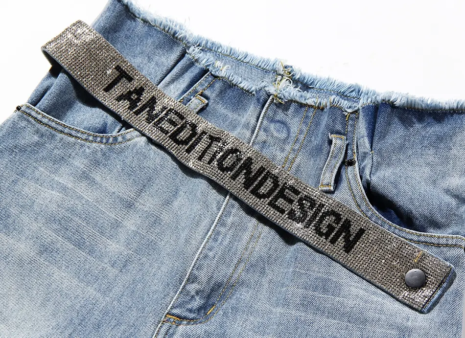 Jean Ouhan femme à jambes larges avec ceinture et strass. Confort et style pour un look tendance. Parfait pour toutes les occasions décontractées.