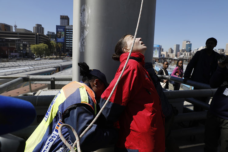 A member of the JMPD retraining a Greenpeace Africa activist during demonstrations on the Nelson Mandela Bridge in Johannesburg on August 28 2018