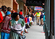 People queue for their monthly social grant payments in Alexandra. File photo. 