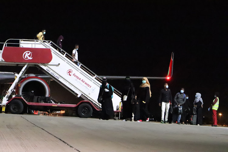 Some of the students disembark from the Kenya Airways plane at the Moi International Airport in Mombasa on Saturday.