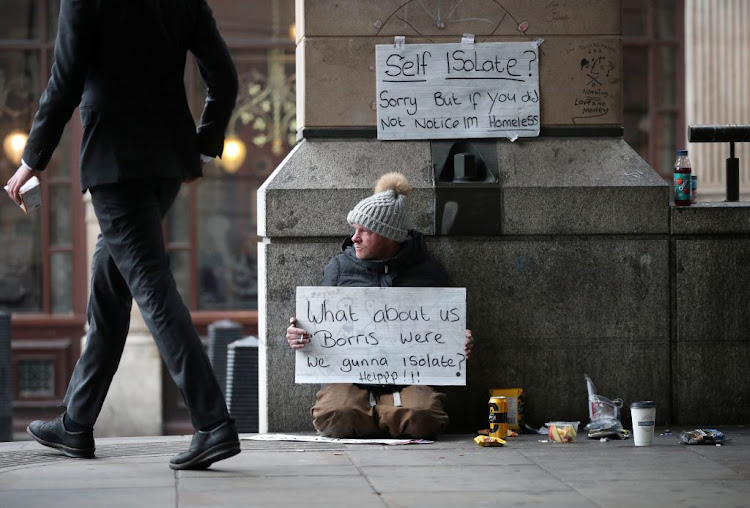 A homeless man holds up a sign outside Westminster underground station as the spread of Covid-19 continues, in London, Britain, on March 19 2020.