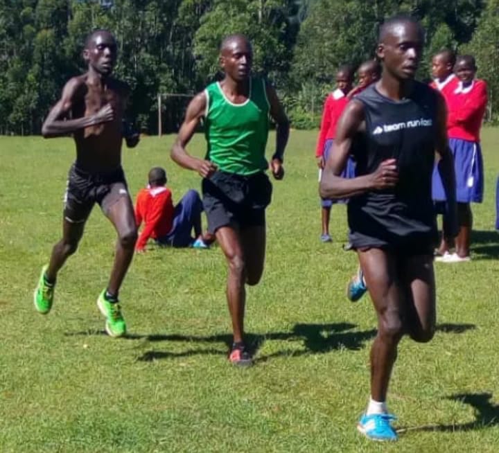 Sammy Nyokaye (behind without a shirt) training with brothers Fredrick Morang'a (in black) and John Morang'a in green at Embaro primary school ground.