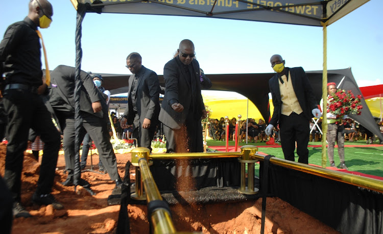 Former EFF secretary-general Godrich Gardee throws soil into his daughter's grave. File photo.