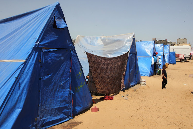 A child looks on, as displaced Palestinians, who fled their houses due to Israeli strikes, shelter at a tent camp, amid the ongoing conflict between Israel and the Palestinian Islamist group Hamas, in Rafah in the southern Gaza Strip, May 5, 2024.