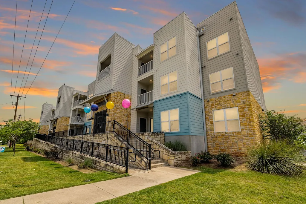 Outside view of Reserve at Springdale at dusk with stairs leading to the entrance and balloons