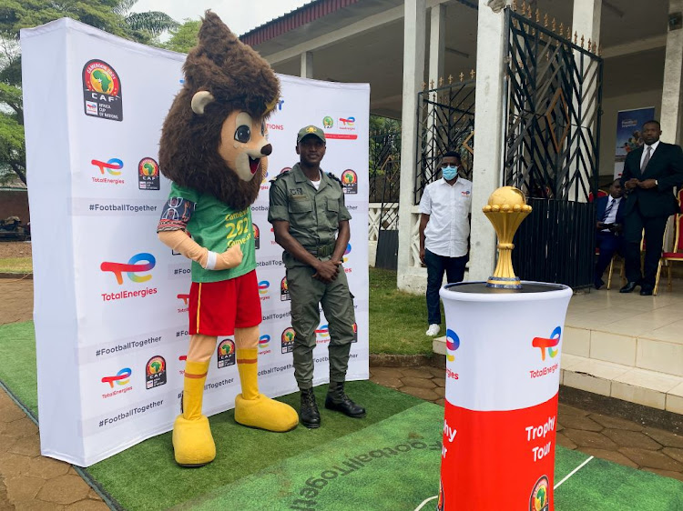 A security forces member poses with the Africa Cup of Nations mascot during the presentation tour of the Cup in Limbe in Cameroon.