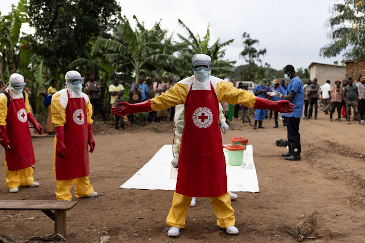 Red Cross workers doff PPE after burying a 3-year-old boy suspected of dying from Ebola on October 13, 2022 in Mubende, Uganda.