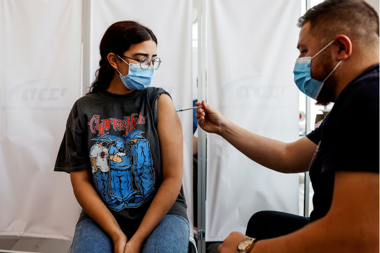 An Israeli woman receives a third shot of a Covid-19 vaccine in Tel Aviv, Israel. Picture: REUTERS/AMIR COHEN