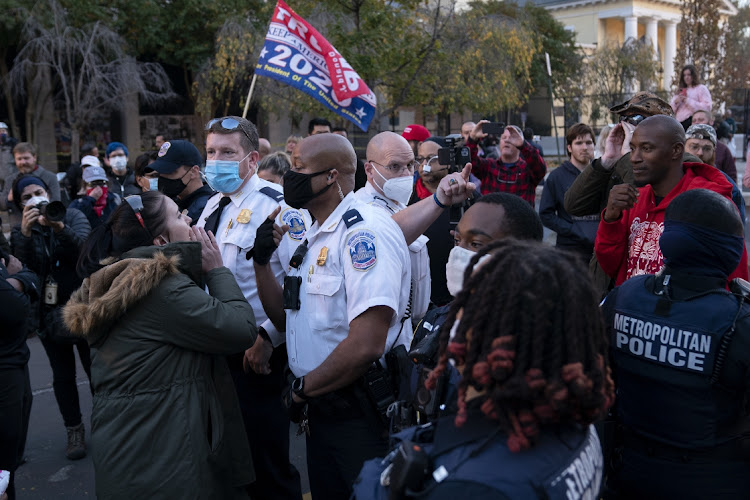 Police officers separate demonstrators from Trump supporters in Washington, D.C., U.S., on Friday, Nov. 13, 2020.