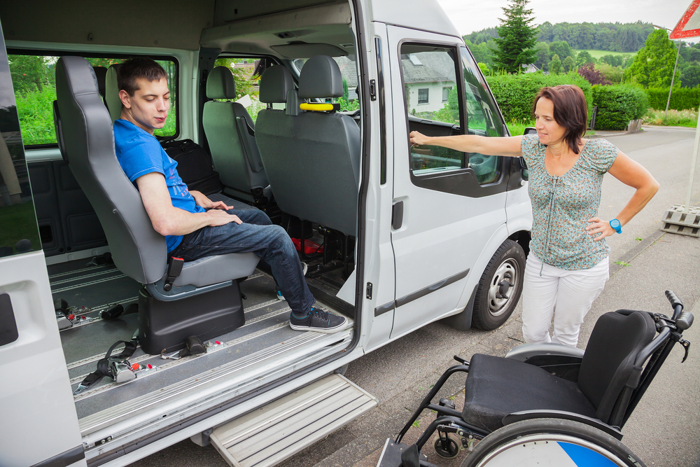 A young man and his caregiver preparing to transfer from a van to his wheelchair