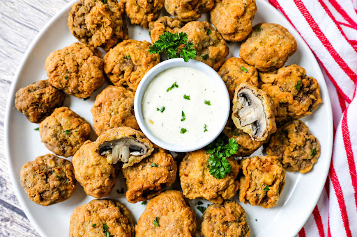 A platter of Deep Fried Mushrooms with dipping sauce.