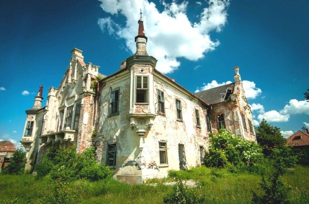 Teleki Castle under blue, cloudy skies in Transylvania, Romania.