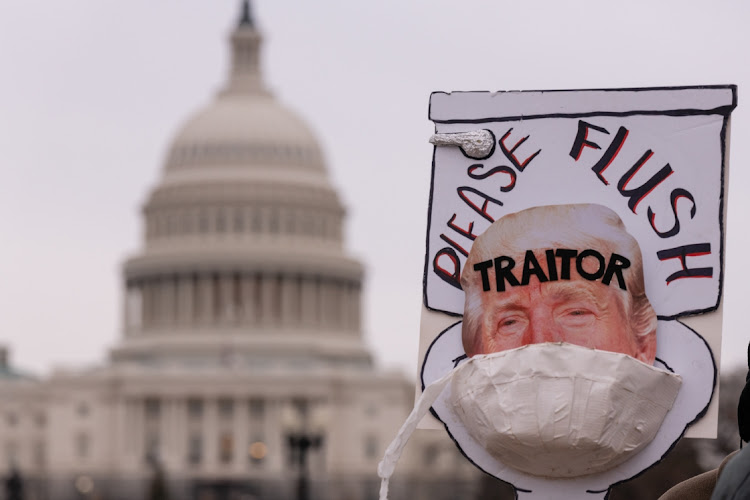 A person holds a sign depicting former US President Trump during a vigil hosted by Declaration for American Democracy on the first anniversary of the deadly insurrection at the US Capitol in Washington, DC, US, on Thursday, January 6, 2022.