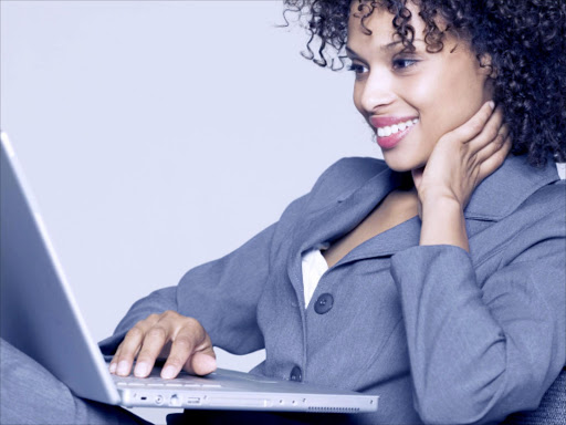 A woman smiles while staring at a computer. Online dating has shot up during coronavirus-induced isolation.