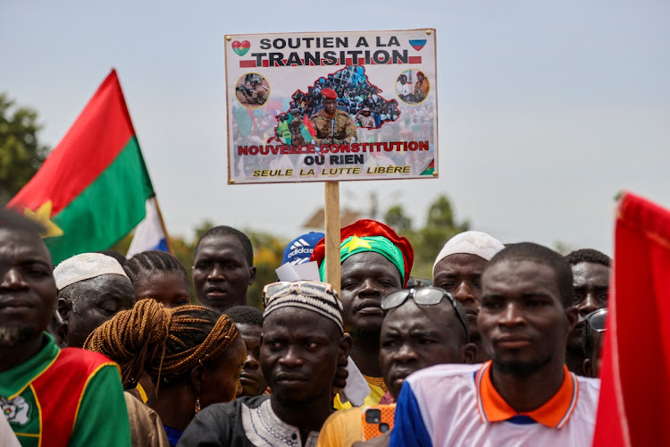 A person holds a sign with a picture of Capt Ibrahim Traore while attending a rally by supporters of Burkina Faso's junta to mark the one-year anniversary of the coup that brought Traore to power in Ouagadougou, Burkina Faso, on September 29 2023.