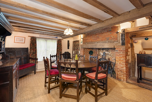 Dining room with wooden table and fireplace - Property purchase in Canterbury, 3 rooms, 6 bedrooms