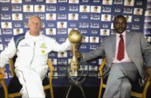 DESPERATE FOR WIN: Mamelodi Sundowns' coach Gordon Igesund and his Orlando Pirates counterpart Bibey Mutombo have the feel of the SAA Supa 8 trophy during a press conference in Johannesburg yesterday. Pic. Antonio Muchave. 11/09/07. © Sowetan.