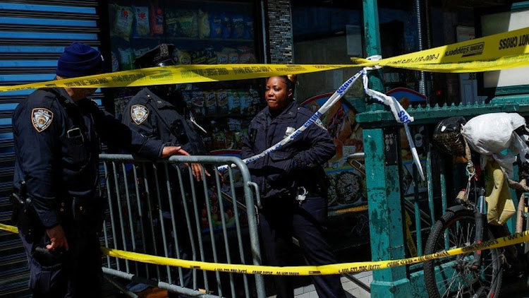 Law enforcement officers stand guard at the scene of the shooting in the Brooklyn borough of New York City