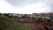 Members of police search and rescue at the scene near Westcliff Secondary School in Chatsworth, south of Durban, where the home of a caretaker was demolished in a mudslide following torrential downpours on April 23 2019. 