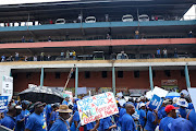 Protesters bearing placards join the DA's march over chronic load-shedding implemented by the ANC government.